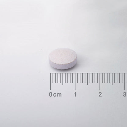 White pill with a ruler for scale on a white background