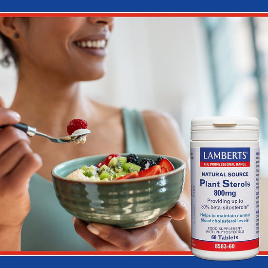 Person eating a bowl of fruit salad with a supplement bottle labeled 'Lambert's' in the foreground.