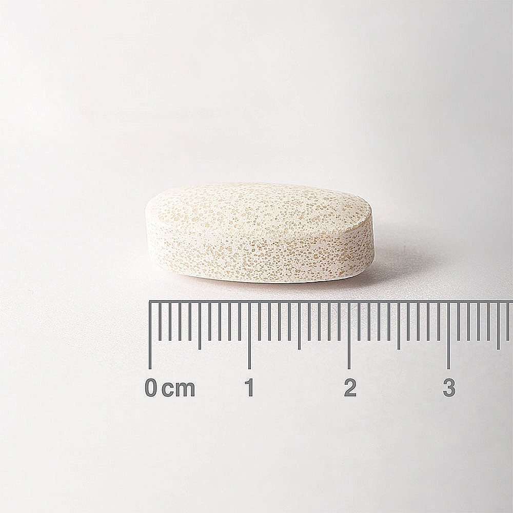 White pill with a ruler for scale on a white background