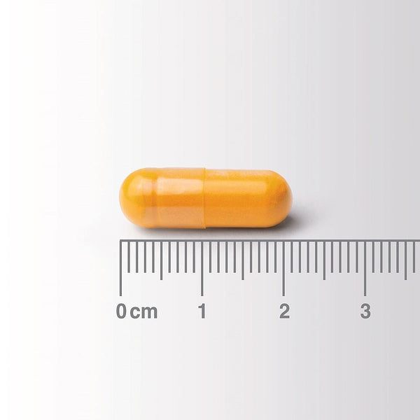 Yellow capsule with a ruler for scale on a white background