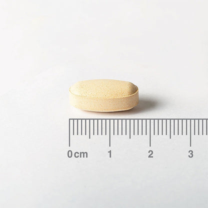Beige pill with a ruler for scale on a white background