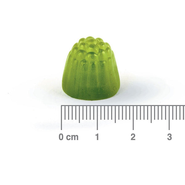 Green gummy with a ruler for scale on a white background