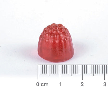 Red gummy with a ruler for scale on a white background