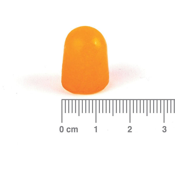 Orange gummy supplement with a ruler for scale on a white background