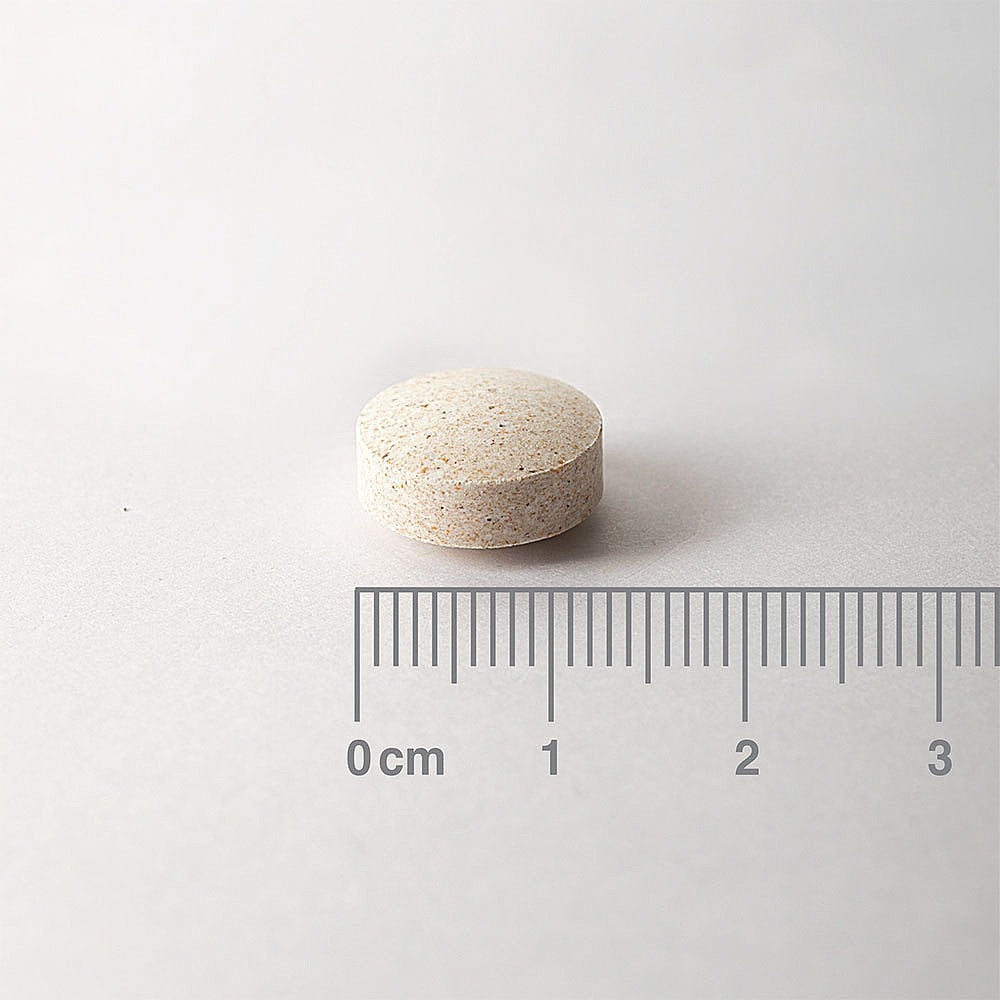 White pill on a light gray background with a ruler for scale.