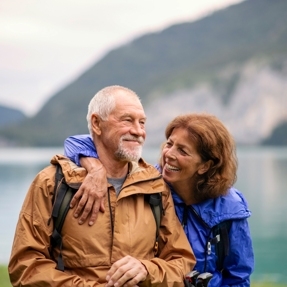 Senior couple hiking with mountains and lake in the background