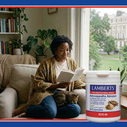 Woman reading a book with a cat on a couch next to a bottle of Lamberts Ashwagandha Advance supplement.