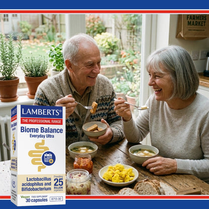Two people enjoying a meal together with a Lamberts Biome Balance supplement box in the foreground.