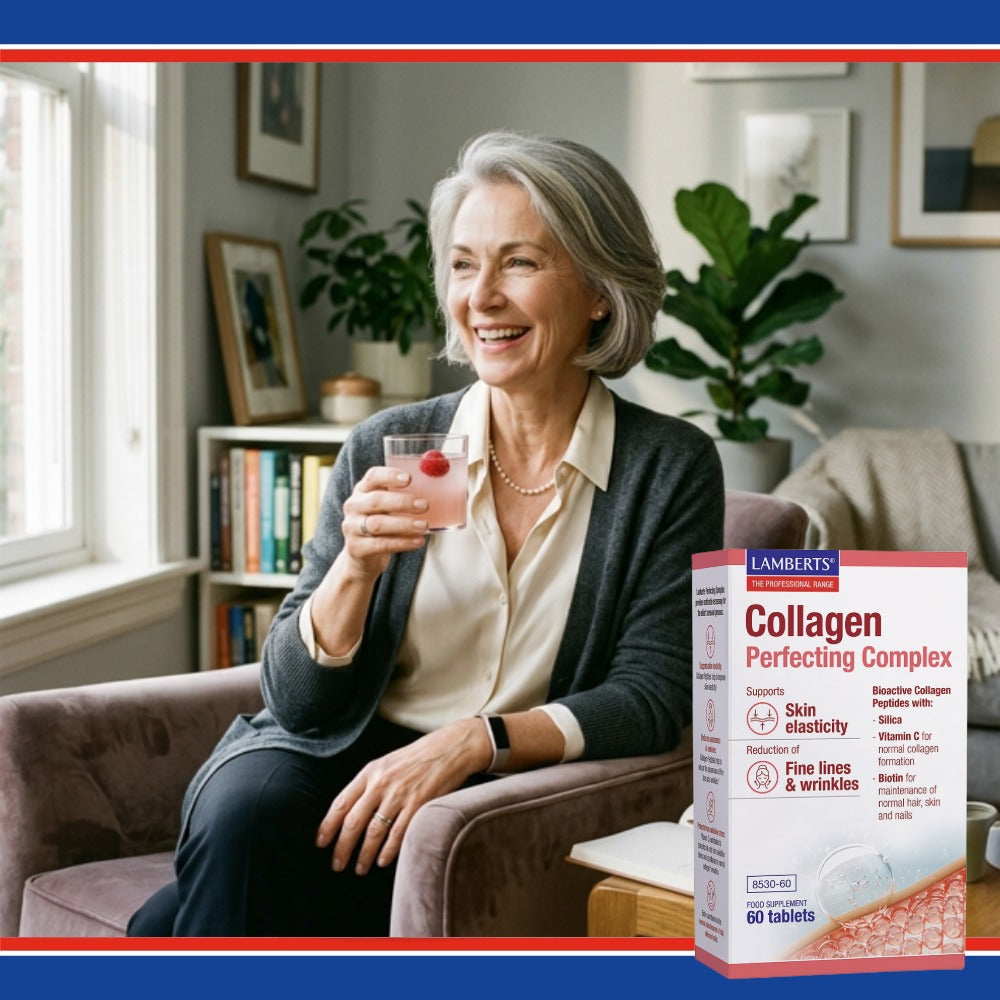 Woman holding a glass of water with a red berry, sitting on a couch in a living room, next to a box of Lamberts Collagen Perfecting Complex.