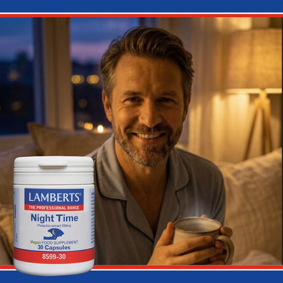 Man holding a mug with a Lamberts Night Time supplement container in a cozy room.