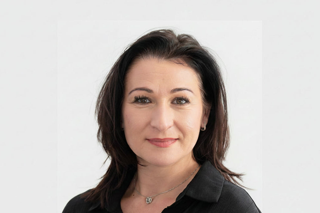 Woman with dark hair wearing a black shirt against a white background
