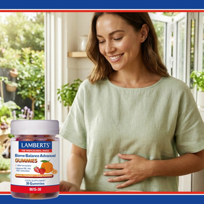 Woman standing in a bright room with a bottle of Lamberts Biome Balance Advanced Gummies.