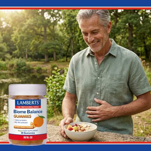 Man holding a bowl of fruit and nuts with a jar of Lamberts Biome Balance Gummies in a natural setting.